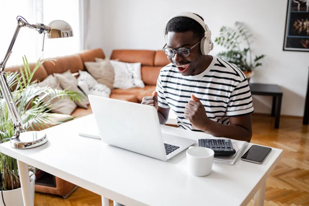 Young man working on a laptop in his living room.