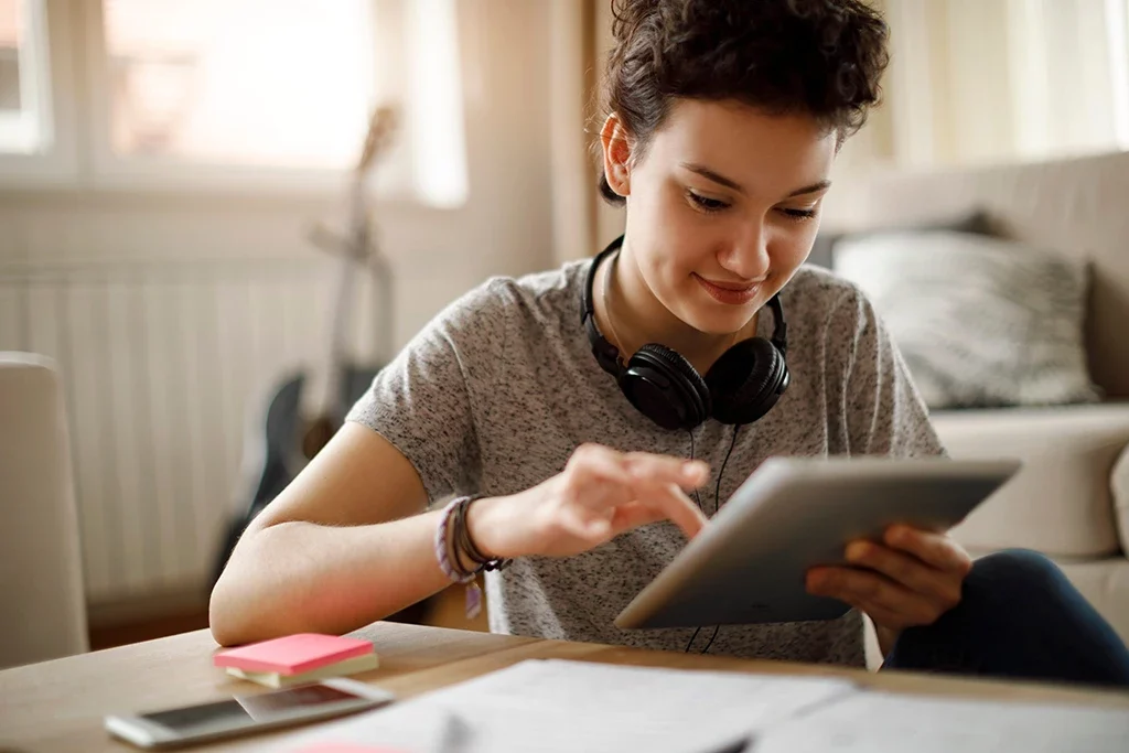 A young woman using a tablet computer at home.